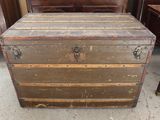 an old trunk sitting on the floor next to a bed