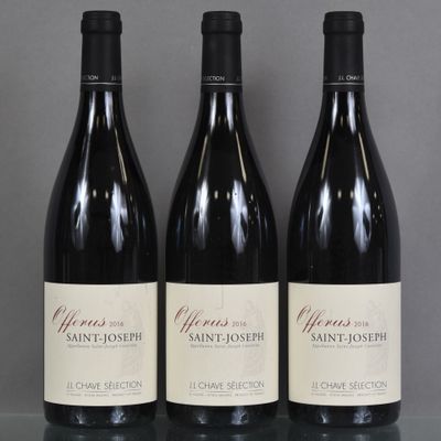 three bottles of wine are lined up on a glass table