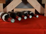 several bottles of wine are lined up on a red table cloth