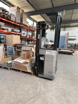 un chariot élévateur dans un entrepôt avec des cartons posés au sol