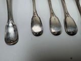 six silver spoons are lined up in a row on a table