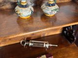 two vases sitting on a wooden shelf with a pen on it