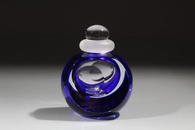 une bouteille en verre bleue munie d'un bouchon blanc