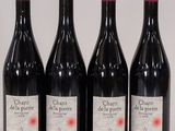 four bottles of red wine are lined up in a row