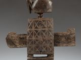 a wooden sculpture of a bird sitting on top of a piece of wood