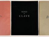 three books are lined up in a row on a white surface