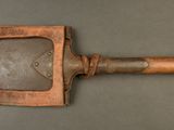 an old wooden spatula with a wooden handle on a gray surface