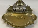 an antique brass plate with a silver inkwell on top of it