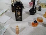 un flacon de parfum posé sur une table à côté d'autres parfums