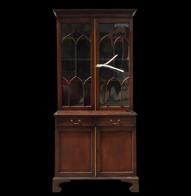 an antique mahogany china cabinet with glass doors