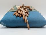 a blue pillow with a bunch of wooden beads on it