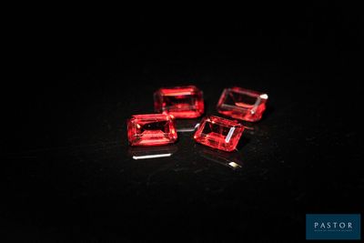 three red glass cubes sitting on top of a black surface