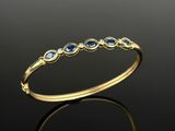 a yellow gold ring with blue sapphires and diamonds