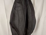 the back of a black jacket hanging on a hanger on a white wall