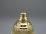 un flacon de parfum posé sur une table, sur fond gris