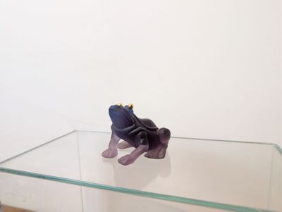 une petite figurine représentant un éléphant violet posée sur une table en verre