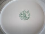 a white plate with a green emblem on it