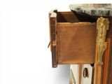 a wooden cabinet with a marble top and brass handles
