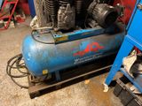 a blue air compressor sitting on top of a blue stand