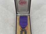 a purple ribbon in a wooden box with a purple ribbon on it