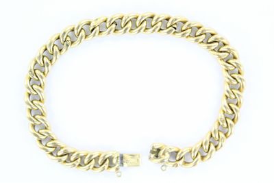 un bracelet en or jaune à maillons de type « curb » sur fond blanc