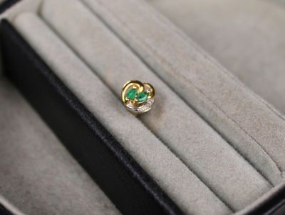une bague sertie d'une pierre verte, dans un écrin