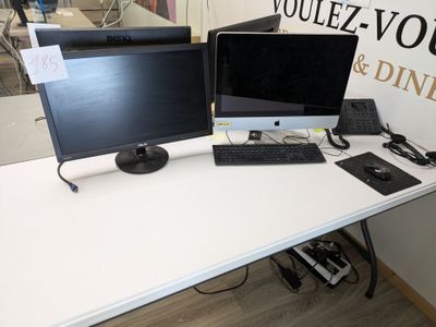 two computer monitors sitting on a desk with a keyboard and mouse