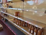 many jars of honey on the shelves in the store