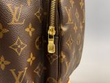un gros plan sur un sac Louis Vuitton marron muni d'une fermeture éclair dorée