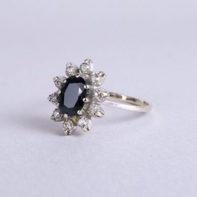 un gros plan d'une bague sertie d'un diamant noir et blanc sur une surface blanche