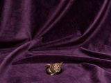 an owl figurine sitting on top of a purple velvet