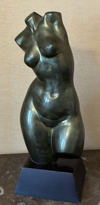une sculpture en bronze représentant un ours assis sur une table