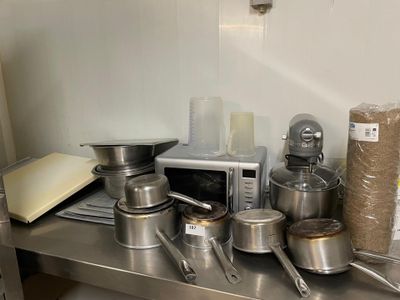 de nombreuses casseroles et poêles posées sur un plan de travail de cuisine