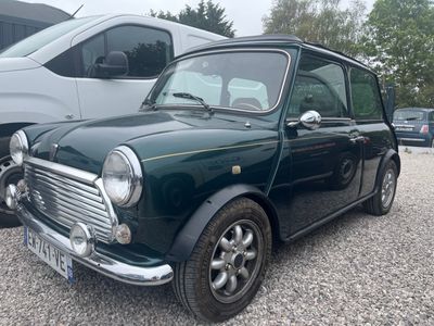 une petite voiture verte garée à côté d'une camionnette blanche