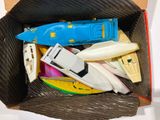 a cardboard box filled with assorted toy boats