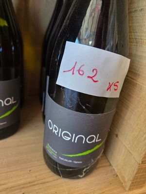 two bottles of wine sitting on a shelf with labels on them