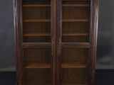 an antique wooden bookcase with glass doors and shelves