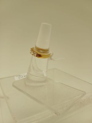 un support en verre transparent surmonté d'un anneau doré