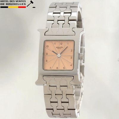 une montre en argent avec un cadran rose et un bracelet en argent