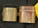 two metal containers sitting next to each other on a black cloth