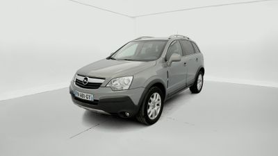 La voiture grise est garée dans une pièce blanche au sol blanc.