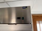 a stainless steel refrigerator with a blue sticker on it