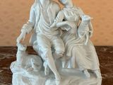 a statue of a man and a woman sitting on a rock