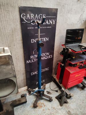 une pancarte indiquant « entreprise de garage » à côté de quelques outils