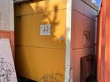 une boîte jaune posée au milieu d'une cour