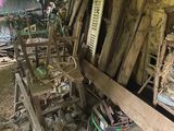 a room full of old wooden chairs in a barn