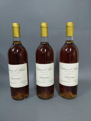 trois bouteilles de vin sont alignées sur une surface grise