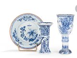 deux vases bleus et blancs et une assiette posés sur un présentoir