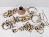a lot of brass musical instruments on a white surface