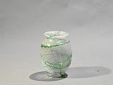 un vase en verre orné d'un motif vert et blanc